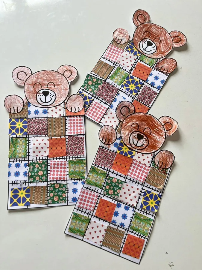 Teddy bears tucked under patterned fabric blankets