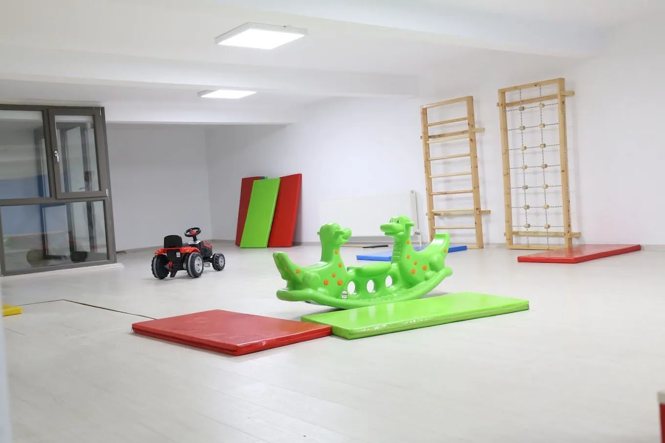 The movement hall: climbing wall, mats and toys