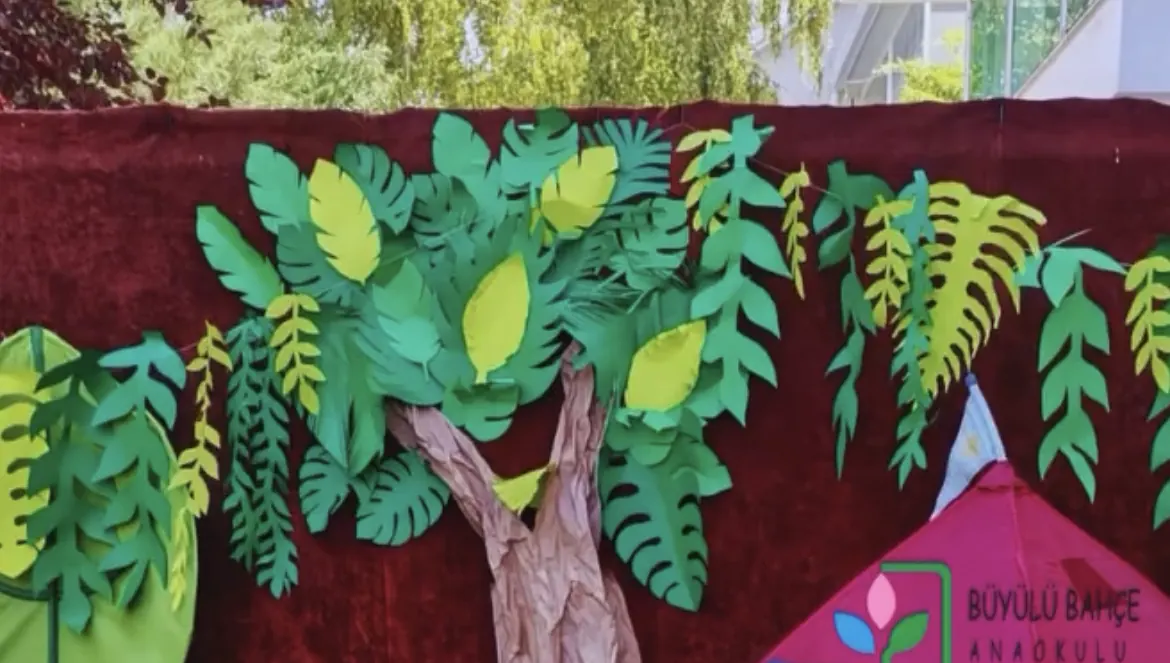 The camp corner in the garden: a paper tree and a tent with our logo