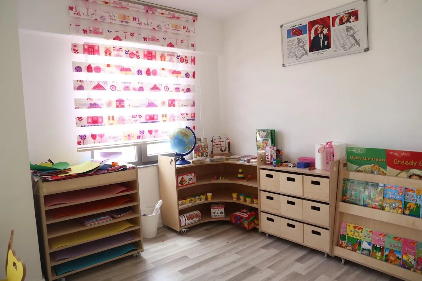 A classroom: materials on shelves, a bookcase and a globe